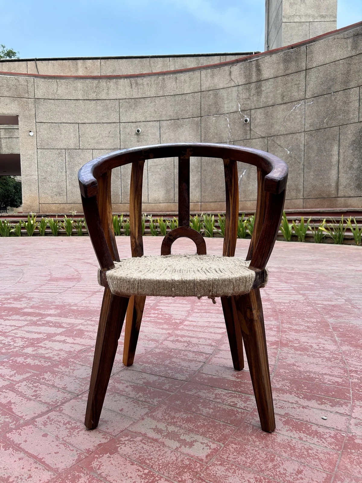 The finished chair standing outdoors on a paved courtyard