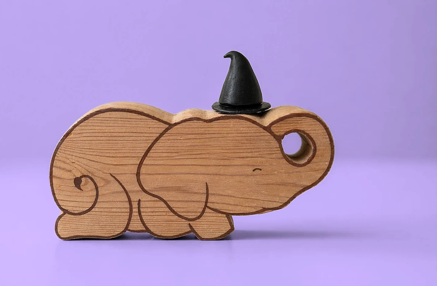 Ellie wearing the black wizard’s hat, on lilac