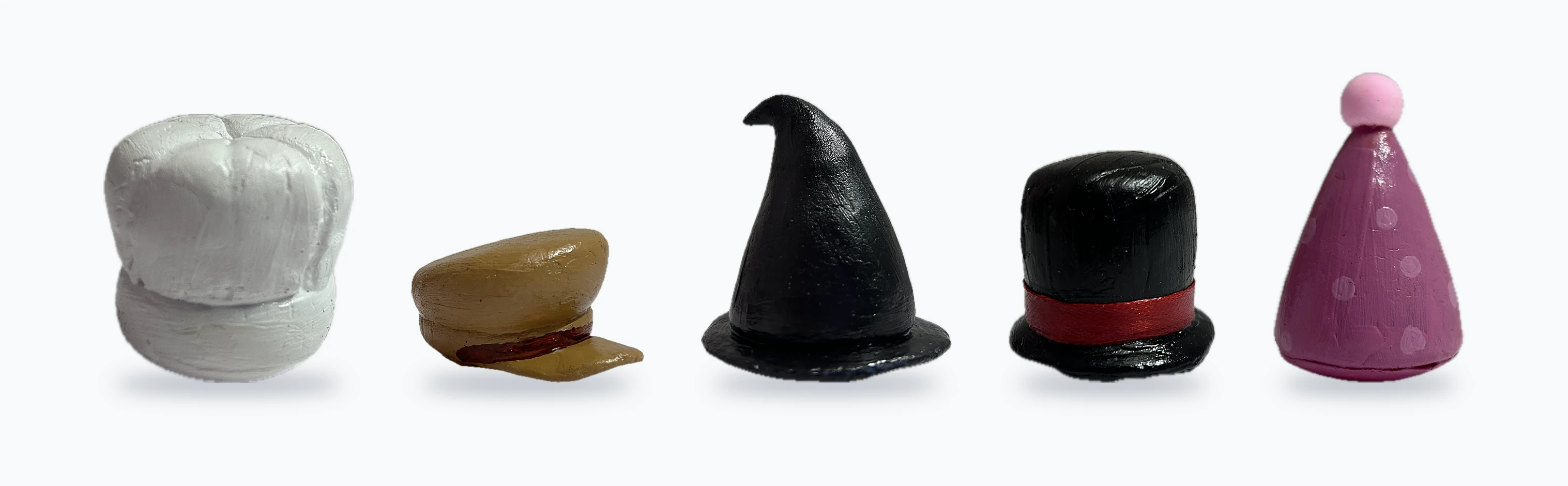 The five clay hats in a row: chef, police cap, wizard, top hat and party hat