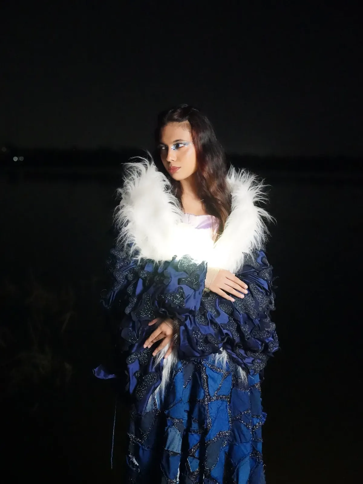 The navy coat with its white fur collar lit from inside